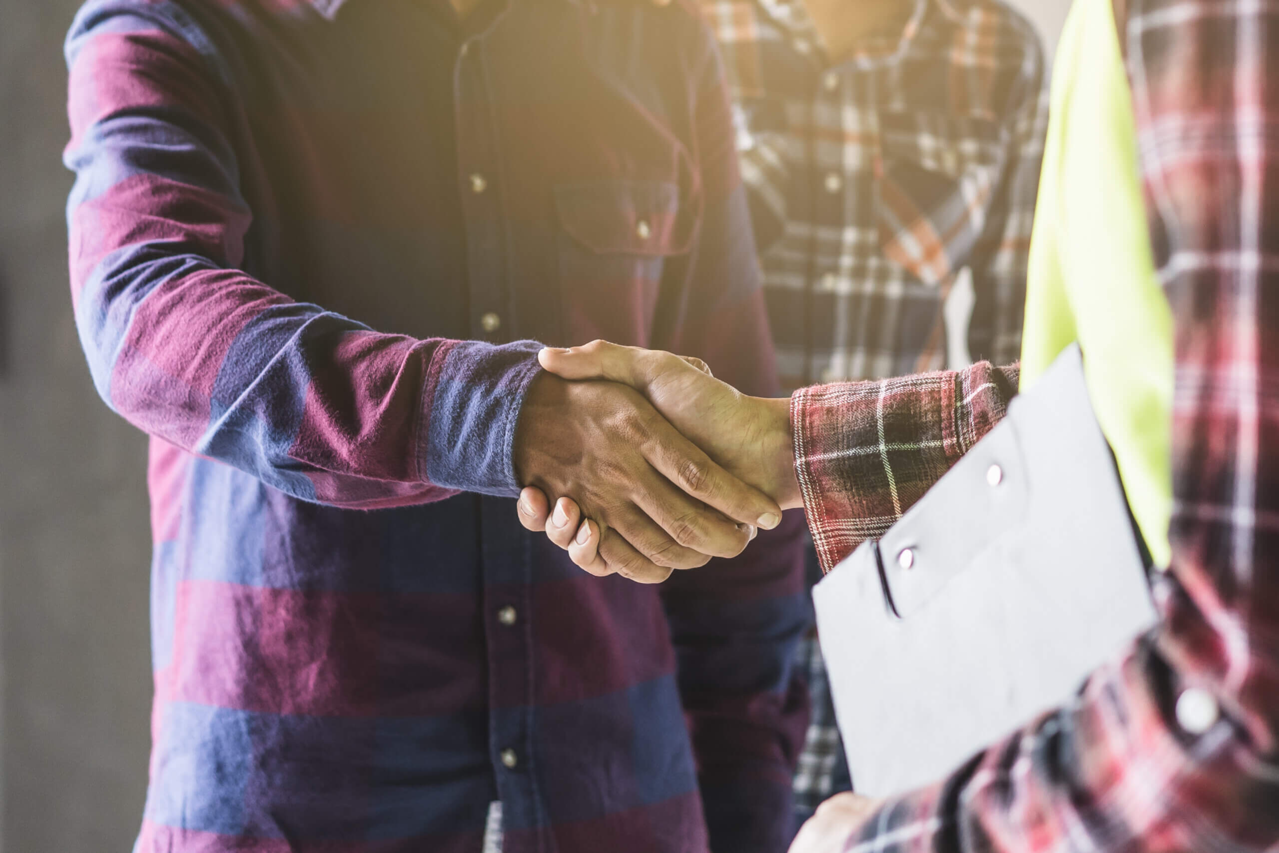 construction worker and contractor. Client shaking hands with team builder in renovation site.