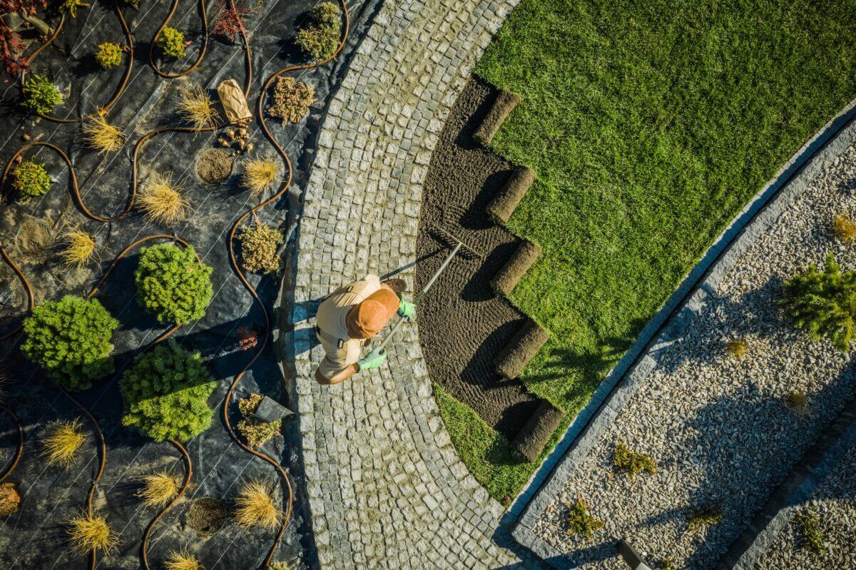 Professional Landscaper Installing Natural Grass Turfs in Newly Developed Residential Backyard Garden. Aerial View.