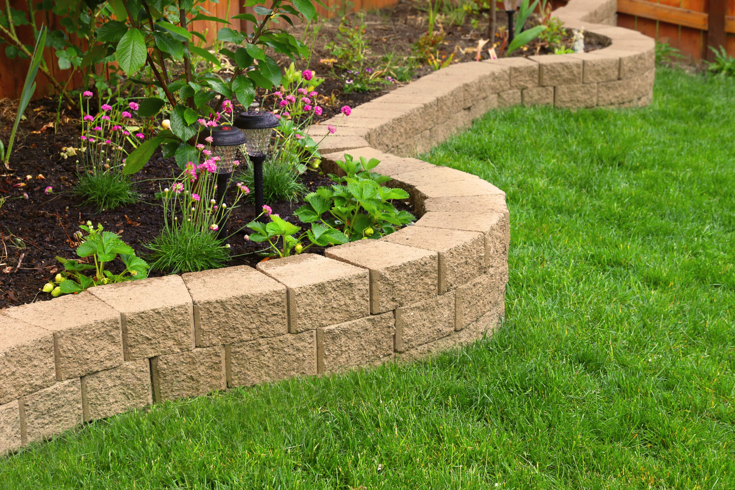 stone wall with perfect grass landscaping in garden with artific