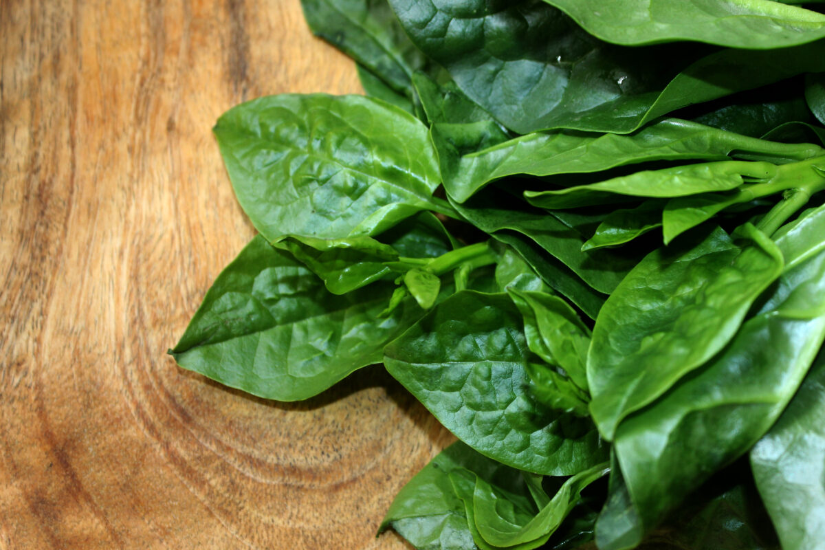 fresh Malabar spinach on wooden background